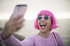 Young woman with pink hair taking a selfie