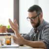 Angry bearded businessman annoyed with phone call in office