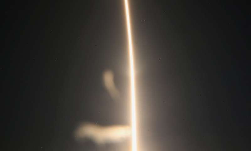 A SpaceX Falcon 9 rocket streaks toward space in this time exposure at liftoff from launch complex 39A at the Kennedy Space Cent