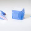 Four small plastic sheets with curved folds forming different structures