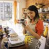 woman smiling on phone while cooking in kitchen