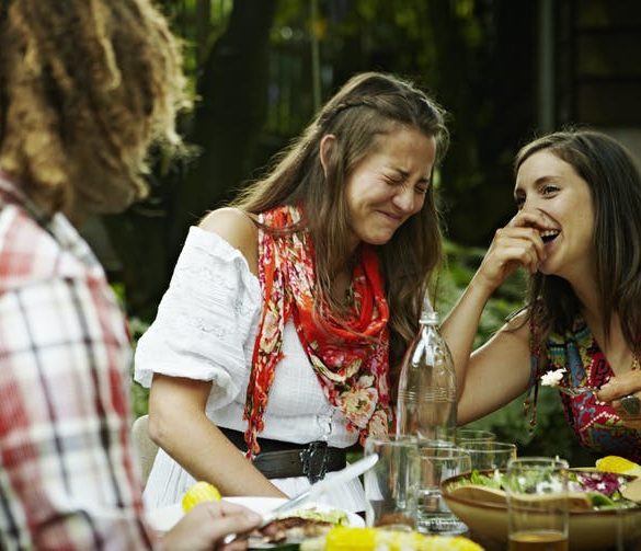 women laughing together at an outdoor meal