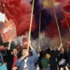 protesters holding signs with flare smoke in background