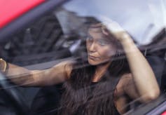 woman seething behind the wheel of a car