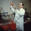 Jonas Salk poses with a flask in lab