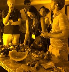 people and fruit lit by yellow low sodium lights