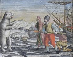A polar bear lunges at men near a ship frozen in ice