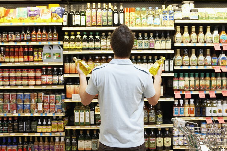 man looking at full grocery shelves