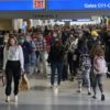 Masked passengers moving through airline terminal