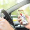 Man driving car and using online map and GPS application on with smart phone. Navigation with mobile app. Inside view in car to hand holding smartphone.