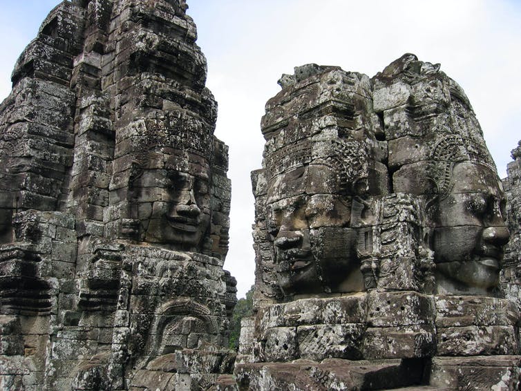 Human faces carved into stone towers of an Angkor temple