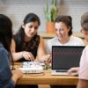 Students at a table use a Moku Go device to test a circuit board.