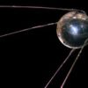 A replica of Sputnik 1 that looks like a silver ball with four long metal lines trailing behind.