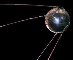 A replica of Sputnik 1 that looks like a silver ball with four long metal lines trailing behind.