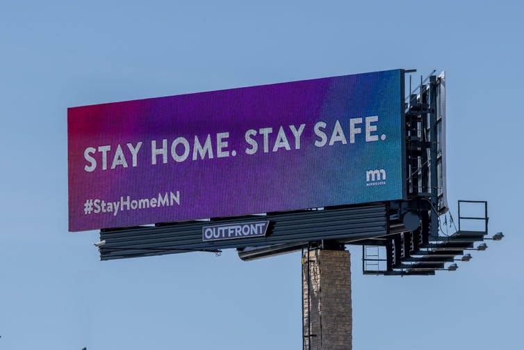 billboard with public health message 'Stay home, stay safe.'