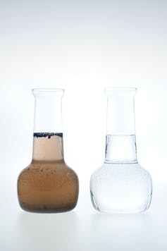 Two glass vials, one containing brown dirty water and the other clean clear water.