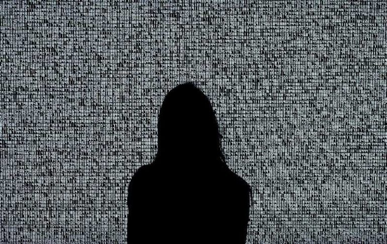 A woman looks at an NFT by Ryoji Ikeda titled 'A Single Number That Has 10,000,086 Digits' during a media preview at Sotheby's i