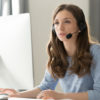 Businesswoman in headset call center agent consulting participating video conference