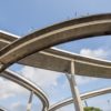 Looking up at a tangle of highway overpasses.