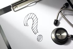 A question mark on a piece of paper next to a stethoscope.