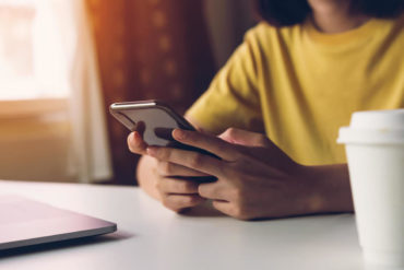 woman holding smartphone, using cell phone on cafe. Technology for communication concept.