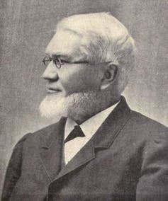 Profile photo of Bishop with a beard and glasses and wearing a suit