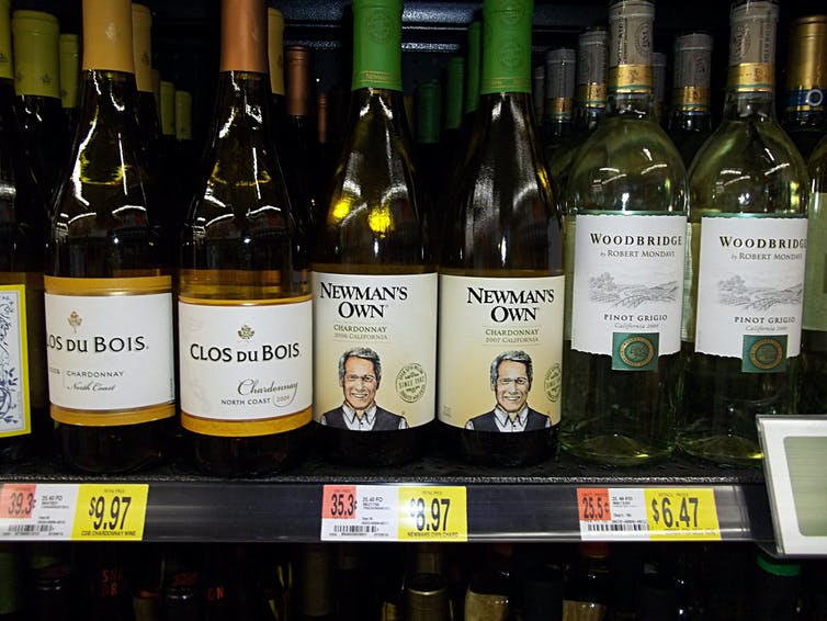 wine bottles on grocery shelf with price labels