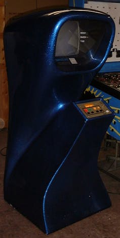 A vertical curvey arcade game console with four buttons on a control surface at the front and a hooded television screen at the top