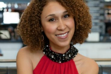 Krystal Covington, a woman with medium-length, curly hair, smiles at the camera.