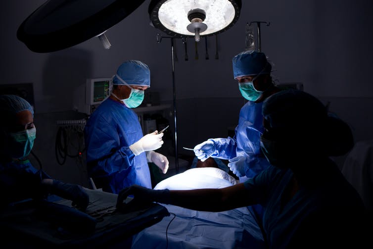 preparing for operation in darkened surgical suite