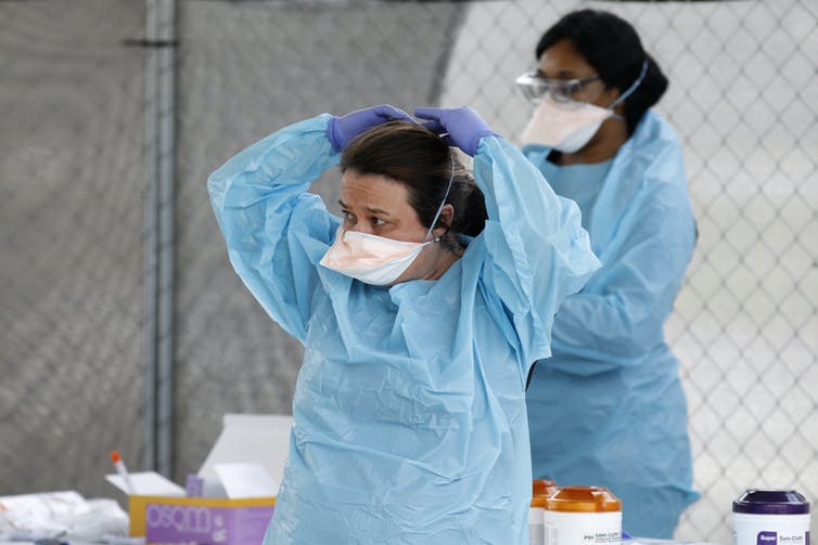 Two health care workers wearing masks.