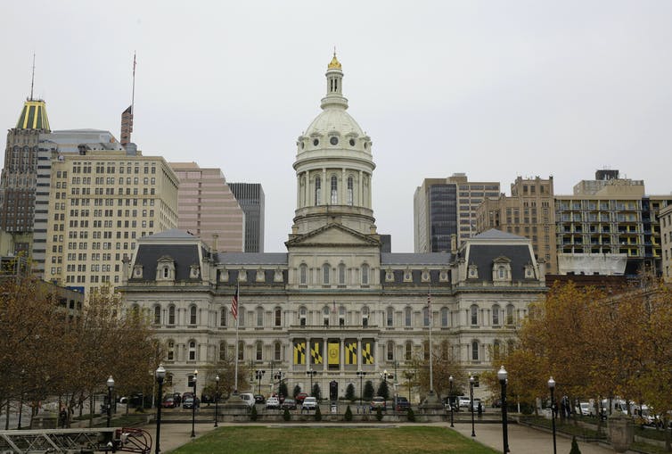 an ornate 19th-century building topped with a dome in a big city downtown