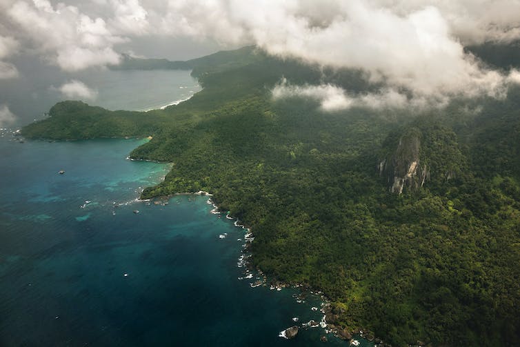 An aerial photo of a heavily forested, mountainous island.