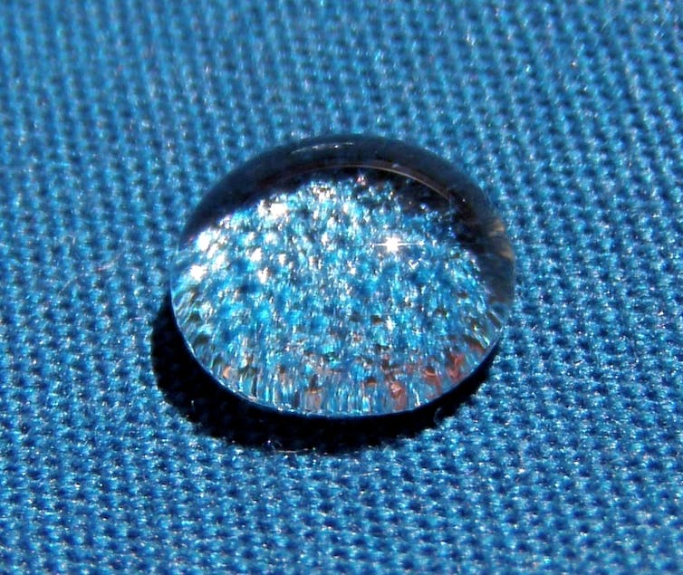 A water droplet sitting on a piece of fabric.