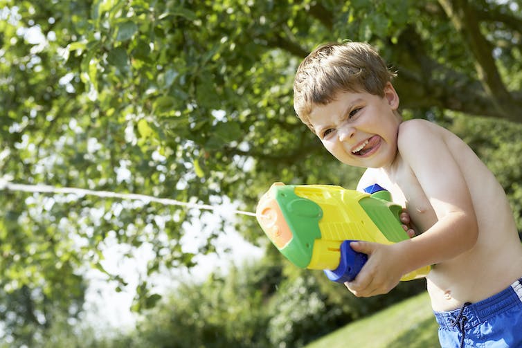 boy playing with colorful water gun