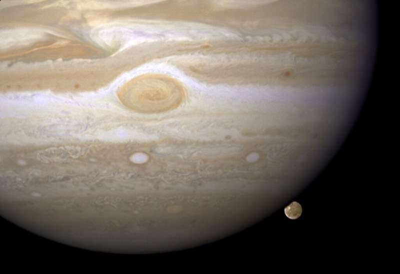 The moon Ganymede lurks behind the gas giant Jupiter in a Hubble telescope image from 2008