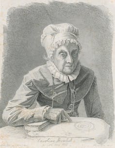 A black and white portrait of an older lady wearing a ruffled bonnet, pointing at a paper. She's holding a magnifying glass.