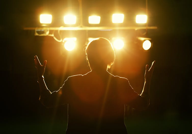 view behind person on stage with spotlights aimed at them