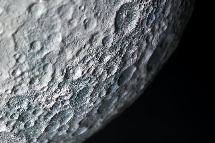 A close up image of craters on the surface of the moon.