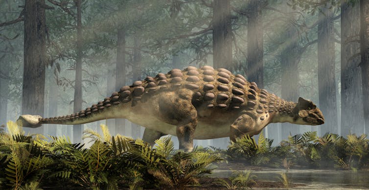 An armored dinosaur with body spikes trudges through a primeval forest.