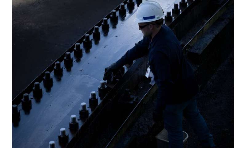 A worker cleans bolts along the track for the Green Bank Telescope, a 100-meter fully steerable radio telescope, at the Green Bank Observatory in the US National Radio Quiet Zone, in Green Bank, West Virginia