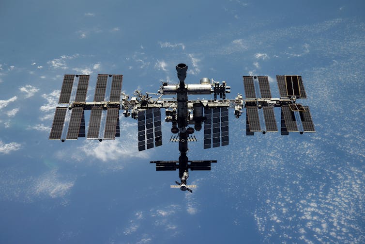 The ISS, a cylindrical craft with solar panels on each side.