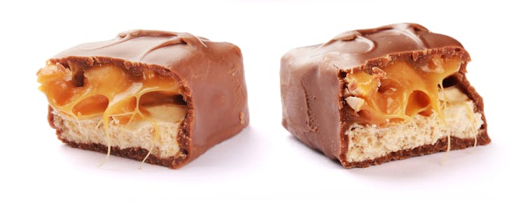 A Snickers bar cut in half, showing cross-sections of its inside.