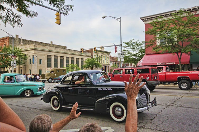 vintage cars mix with traffic in a small city street