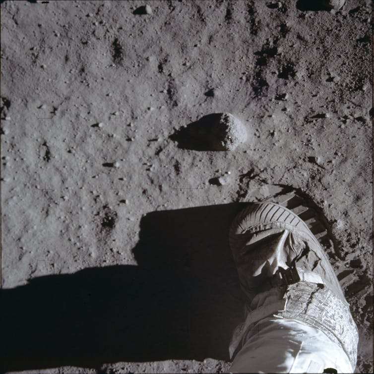 A photo, shown from above, of an astronaut's boot and boot print on the lunar surface.