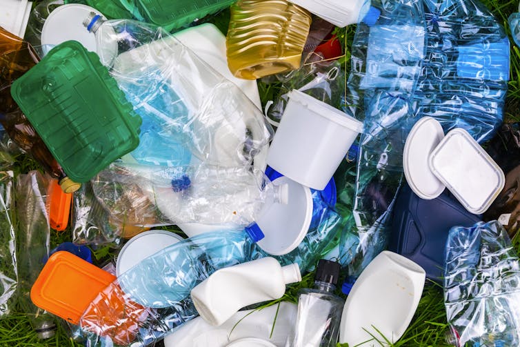 A pile of empty plastic bottles and containers of varying colors.