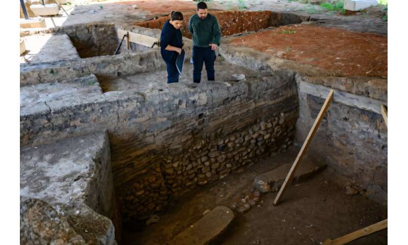 Archaeologists Murat Turkteki and Deniz Sari examine an ancient house at the Kulluoba excavation site in central Turkey