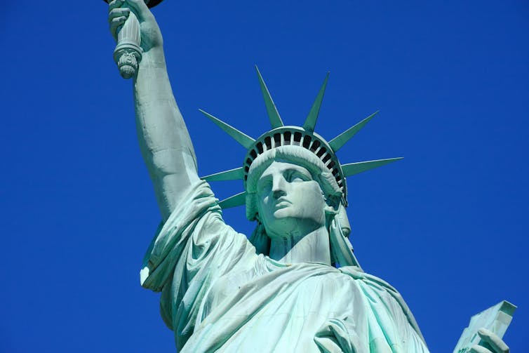 The Statue of Liberty in New York against a bright blue sky