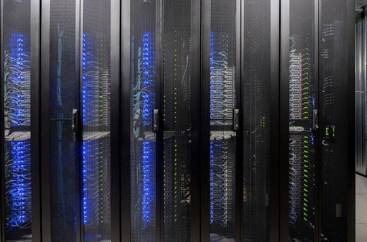 Small blue and green lights arranged in columns glow behind black mesh screens