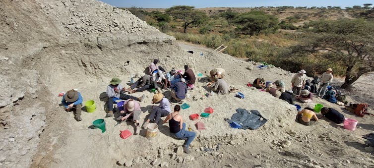 people sitting on dusty ground at an archaeological dig